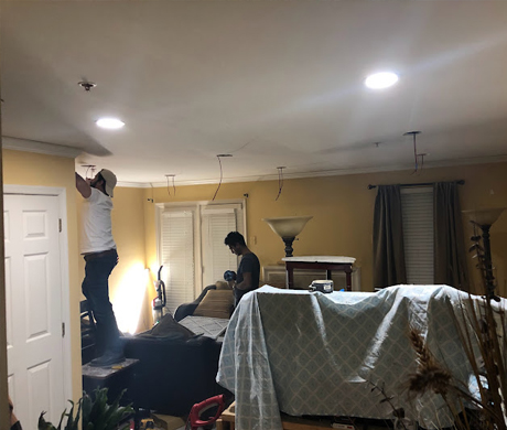 cropped view of handyman in uniform holding hammer while repairing roof